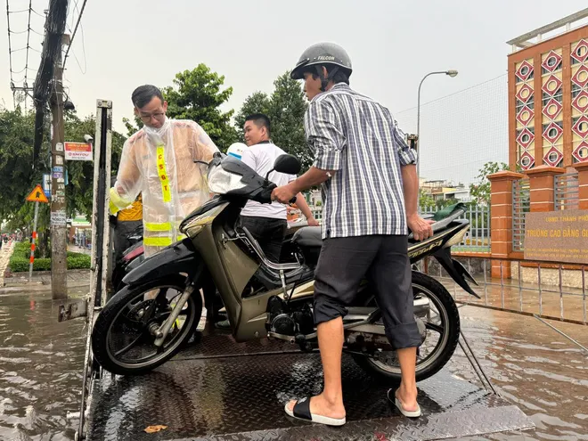 CSGT dùng xe đặc chủng chở dân qua đường ngập ở TP Hồ Chí Minh - Ảnh 2.