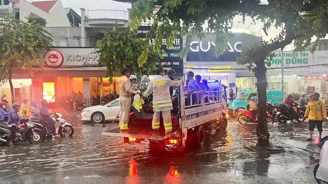 CSGT dùng xe đặc chủng chở dân qua đường ngập ở TP Hồ Chí Minh - Ảnh 3.