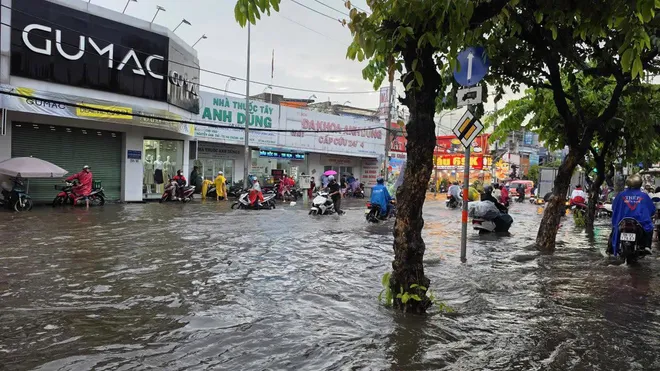 CSGT dùng xe đặc chủng chở dân qua đường ngập ở TP Hồ Chí Minh - Ảnh 1.