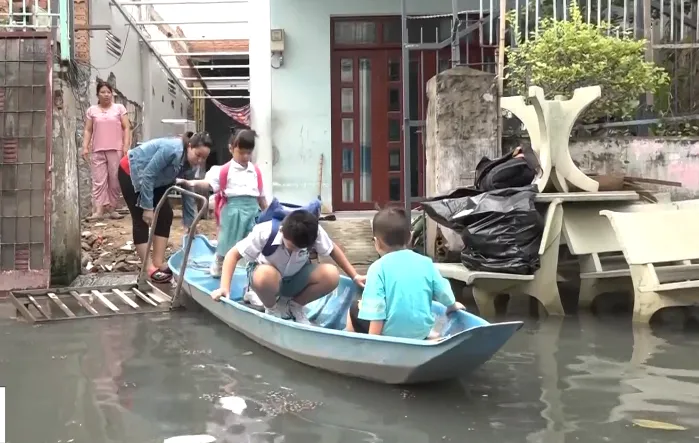 Ngập mãi không hết, người dân chèo xuồng đưa con đi học giữa phố - Ảnh 1.
