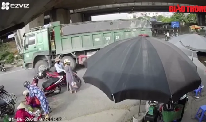 VIDEO: Xe ben cuốn xe máy vào gầm, người phụ nữ ngã văng ra khỏi bánh xe - Ảnh 1. VIDEO: Xe ben cuốn xe máy vào gầm, người phụ nữ ngã văng ra khỏi bánh xe - Ảnh 1.