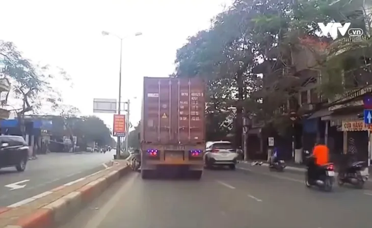 Cố lách vượt xe container, tài xế xe máy bị ngã gãy chân - Ảnh 2. Cố lách vượt xe container, tài xế xe máy bị ngã gãy chân - Ảnh 2.