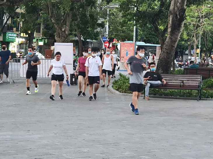 Hà Nội: Trên hồ Hoàn Kiếm nhiều người vẫn vô tư tập thể dục, hồ Tây đã giảm bớt - Ảnh 1. Hà Nội: Trên hồ Hoàn Kiếm nhiều người vẫn vô tư tập thể dục, hồ Tây đã giảm bớt - Ảnh 1.