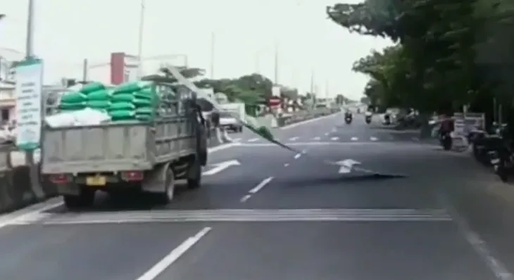 Va phải đèn đường, tấm tôn lao khỏi thùng xe tải xuống đường - Ảnh 1. Va phải đèn đường, tấm tôn lao khỏi thùng xe tải xuống đường - Ảnh 1.