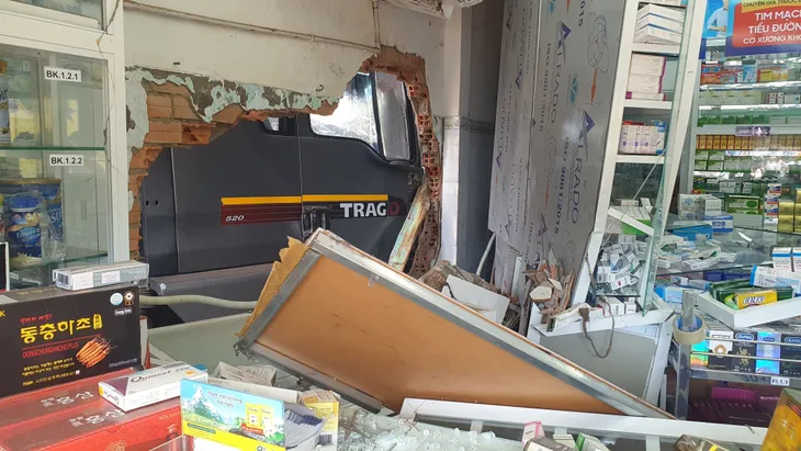 Xe ben tự trôi dốc, lao vào tiệm sửa xe và hiệu thuốc - Ảnh 1. Xe ben tự trôi dốc, lao vào tiệm sửa xe và hiệu thuốc - Ảnh 1.