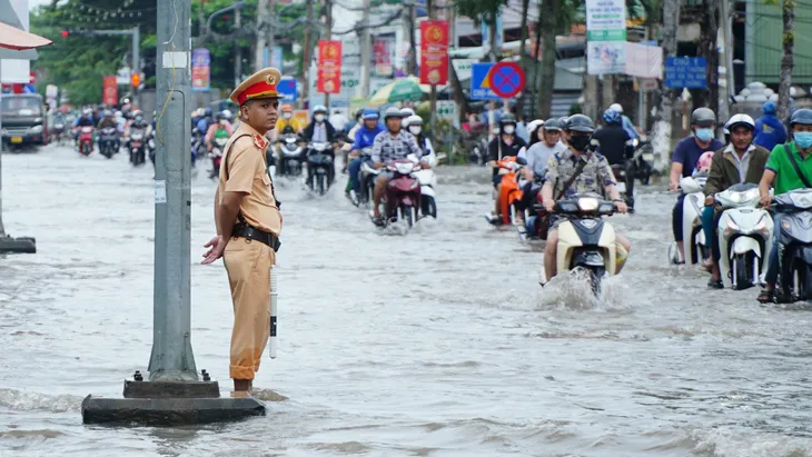 Triều cường vượt báo động 3, người dân bì bõm lội nước ngày đầu tuần - Ảnh 1.