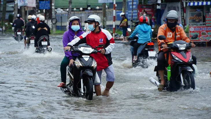 Triều cường vượt báo động 3, người dân bì bõm lội nước ngày đầu tuần - Ảnh 4.