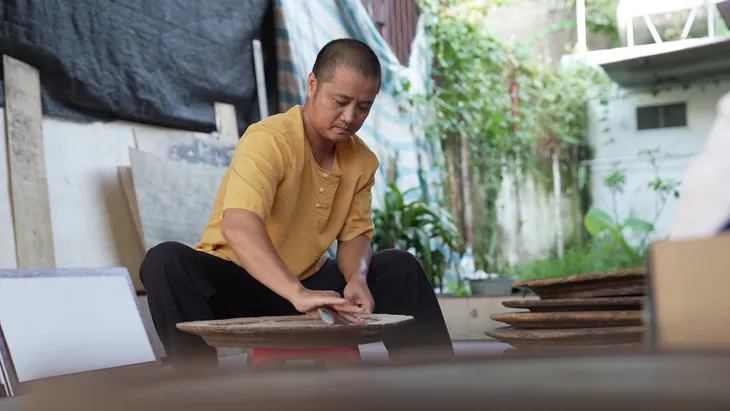 Họa sĩ vẽ tranh trên mâm gỗ và tình yêu với văn hóa truyền thống - Ảnh 1. Họa sĩ vẽ tranh trên mâm gỗ và tình yêu với văn hóa truyền thống - Ảnh 1.