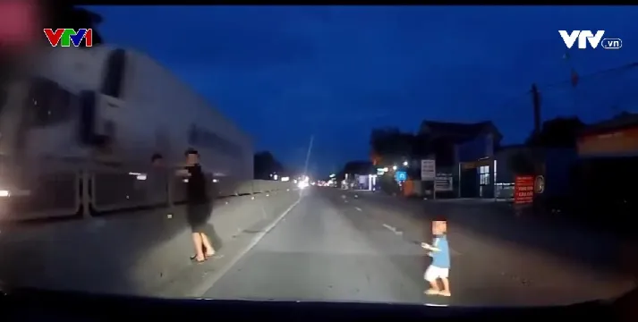 Thót tim với tình huống cháu bé băng sang đường trước đầu ô tô - Ảnh 2. Thót tim với tình huống cháu bé băng sang đường trước đầu ô tô - Ảnh 2.