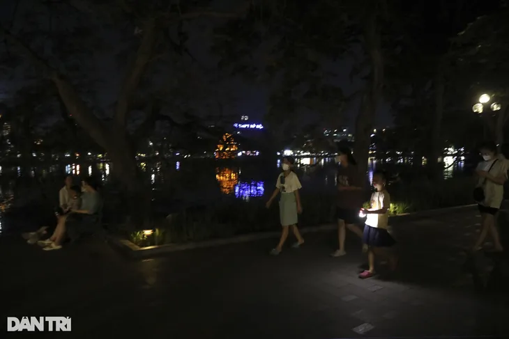 Hà Nội tắt đèn tiết kiệm điện, phố đi bộ hồ Gươm hoạt động trong bóng tối - Ảnh 1.