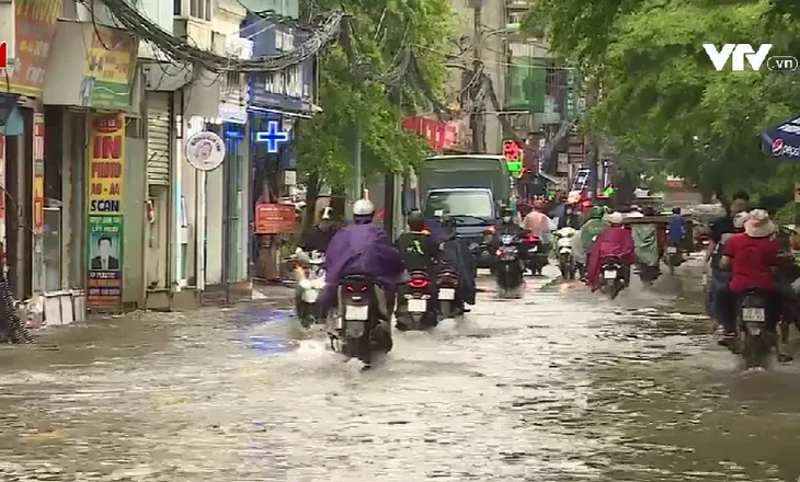 Mưa trắng trời, đường phố Hà Nội biến thành sông - Ảnh 1. Mưa trắng trời, đường phố Hà Nội biến thành sông - Ảnh 1.