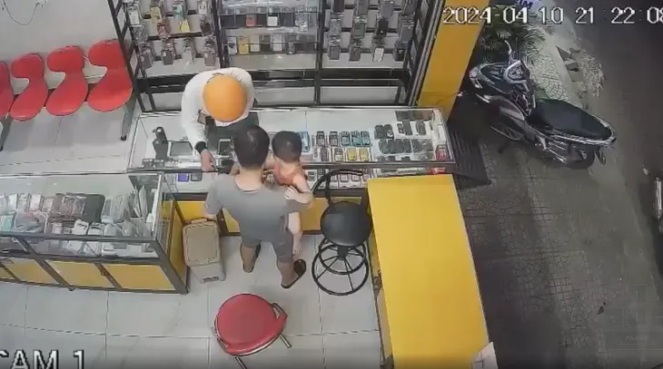 Chủ cửa hàng đang bế con tóm gọn tên cướp điện thoại - Ảnh 1. Chủ cửa hàng đang bế con tóm gọn tên cướp điện thoại - Ảnh 1.