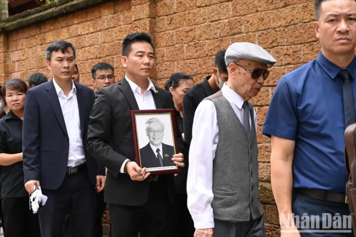 Người dân xúc động mang di ảnh Tổng Bí thư đến lễ viếng - Ảnh 1. Người dân xúc động mang di ảnh Tổng Bí thư đến lễ viếng - Ảnh 1.