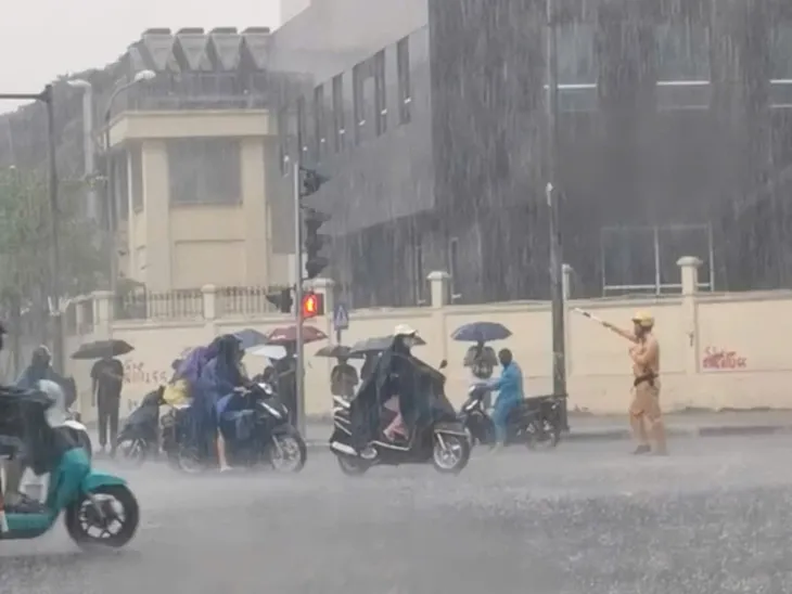 CSGT Hà Nội đội mưa phân luồng giao thông nhận nhiều lời khen - Ảnh 1. CSGT Hà Nội đội mưa phân luồng giao thông nhận nhiều lời khen - Ảnh 1.