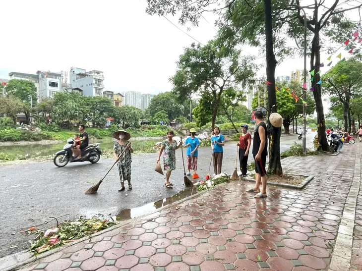Người dân Hà Nội dọn dẹp đường phố sau cơn bão - Ảnh 1. Người dân Hà Nội dọn dẹp đường phố sau cơn bão - Ảnh 1.
