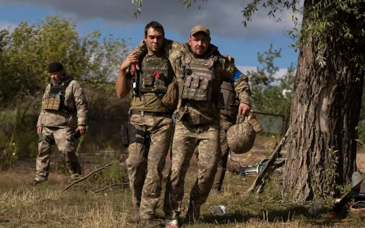 Một quân nhân Ukraine giúp đỡ đồng đội trong quá trình sơ tán. (Ảnh: AP) Một quân nhân Ukraine giúp đỡ đồng đội trong quá trình sơ tán. (Ảnh: AP)
