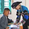 Young Bo Y ethnic teacher plants seeds of knowledge in children