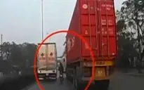 Xe máy “liều mình” lách giữa xe tải và container