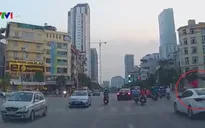 Hai bé gái ngồi vắt vẻo trên nóc ôtô chạy giữa phố Hà Nội