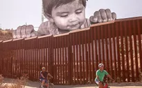 Chân dung bé trai di cư khổng lồ ngó qua biên giới Mỹ - Mexico
