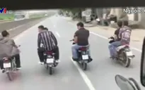 Nhóm thanh niên không đội mũ bảo hiểm, dàn hàng ngang trước đầu ô tô trên quốc lộ