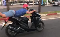 Xử phạt nam thanh niên nằm trên yên điều khiển xe máy