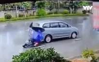 Vừa đi xe vừa cầm ô, cô gái lao thẳng vào đuôi ô tô