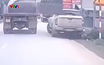 Cửa thùng xe tải mở toang đập vỡ kính xe bán tải đỗ ven đường