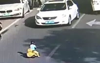 Giải cứu em bé lái ô tô đồ chơi giữa đường phố