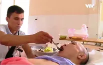 Chàng trai ngồi xe lăn chăm bạn bị liệt