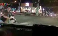 Nam thanh niên đi xe máy cố tình vượt ẩu, tung chân đạp ô tô