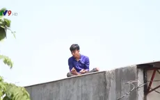 Giải cứu thanh niên nghi ngáo đá trèo lên nóc nhà dân ở TP.HCM