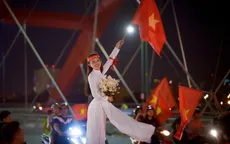 Thú vị hình ảnh thiếu nữ mặc áo dài vẫy cờ cổ vũ ĐT Việt Nam trên cầu Bình Lợi