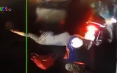 Áo mưa vướng vào bánh xe, người ngồi sau xe máy ngã nhào xuống đường