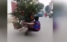 Thót tim người phụ nữ ngồi chênh vênh bên chậu hoa trên xe máy