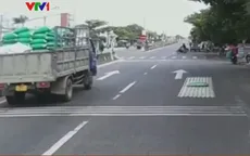 Va phải đèn đường, tấm tôn lao khỏi thùng xe tải xuống đường