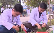 Nhân viên y tế và người nhà bệnh nhân gói bánh chưng đón Tết