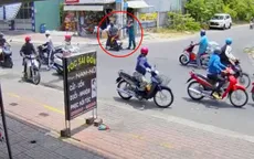 Người mặc trang phục dân quân tự vệ dùng gậy đánh vào đầu nam sinh