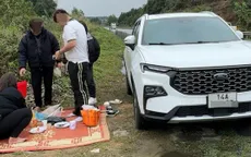 Gia đình 4 người trải chiếu ngồi ăn cơm cạnh cao tốc Nội Bài - Lào Cai