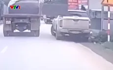 Cửa thùng xe tải mở toang đập vỡ kính xe bán tải đỗ ven đường