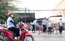 Nhiều người dân TP Hồ Chí Minh liều lĩnh trèo dải phân cách băng qua đường để kịp giờ làm