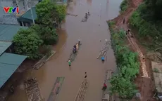 Người dân chế mảng, làm cầu phao bằng tre di chuyển qua đoạn ngập sâu trên Quốc lộ 279