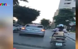 Một phụ nữ chở theo con nhỏ, chạy tốc độ cao trên đường