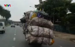 Xe máy chở hàng quá khổ, phóng nhanh giữa đường phố