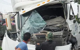 Xe container húc xe tải bay lên dải phân cách, tài xế kẹt cứng trong cabin