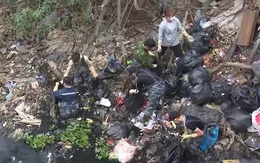 Thanh niên tình nguyện ngâm mình nhiều giờ dưới sông đen kịt để vớt rác