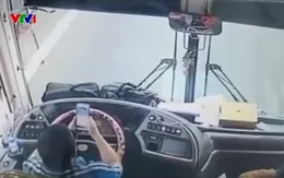 Tài xế thản nhiên xem điện thoại, lái ô tô bằng khuỷu tay