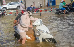 Tình nguyện viên dầm mưa, lội nước giúp người dân trong triều cường