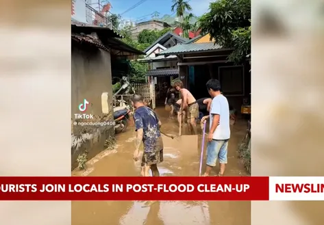Tourists join locals in post-flood clean-up