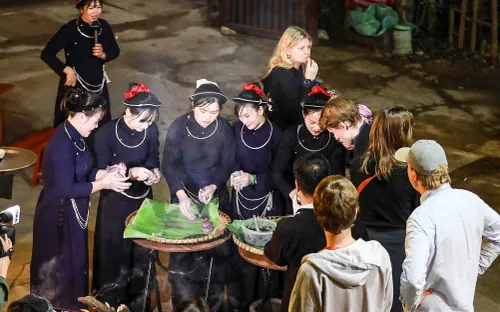 Du khách quốc tế thích thú trải nghiệm giã bánh dày lá cẩm khi đến Ba Bể